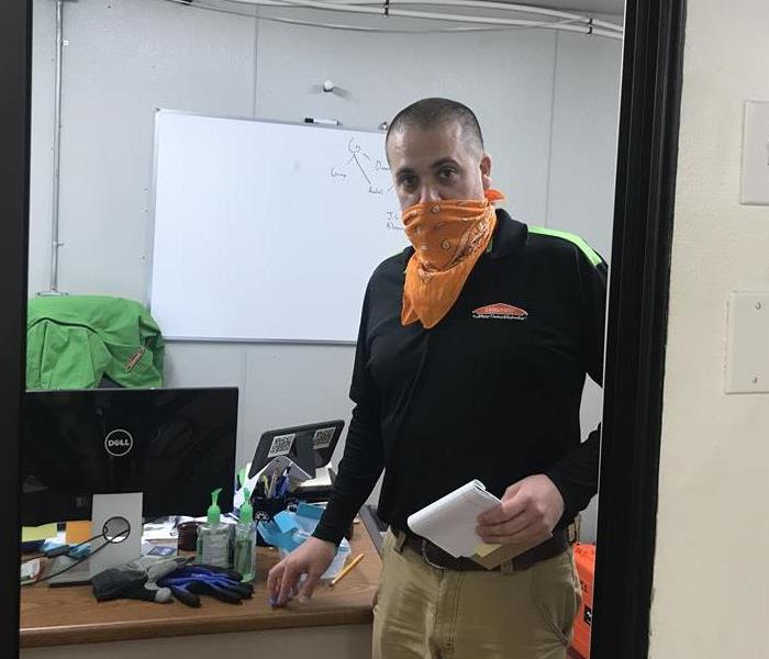 production manager with orange scarf over mouth
