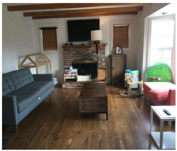 Living room with grey couch brick fireplace coffee table & rocking horse
